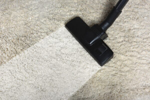 The Carpet Cleaners - close-up view of cleaning white carpet with professional vacuum